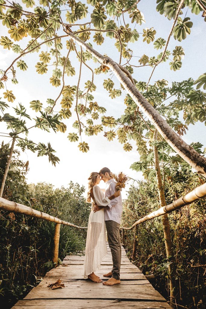 Newlyweds standing on wooden footbridge